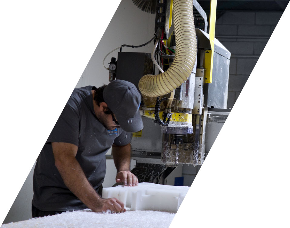 carriere_image1_AxDecoupe Machiniste retirant une pièce de plastique fraîchement usinée de la table de découpe CNC