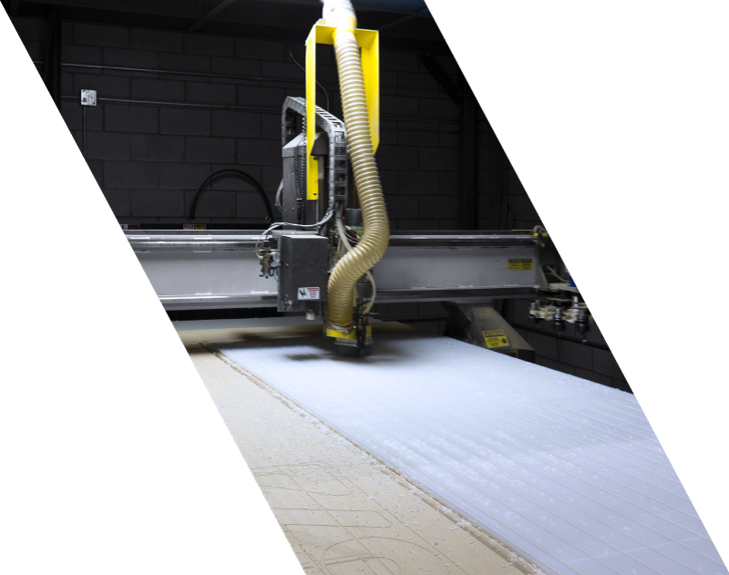 Table de découpe CNC en opération sur une feuille de plastique chez AX-Découpe
